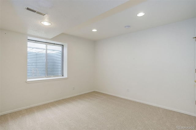 carpeted spare room featuring recessed lighting, visible vents, and baseboards