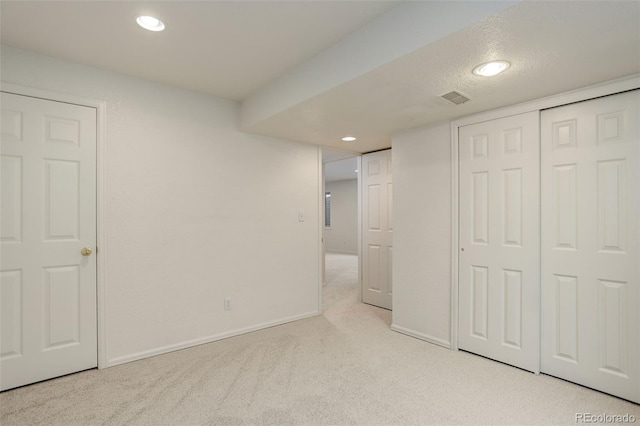 unfurnished bedroom with a closet, recessed lighting, carpet flooring, and baseboards