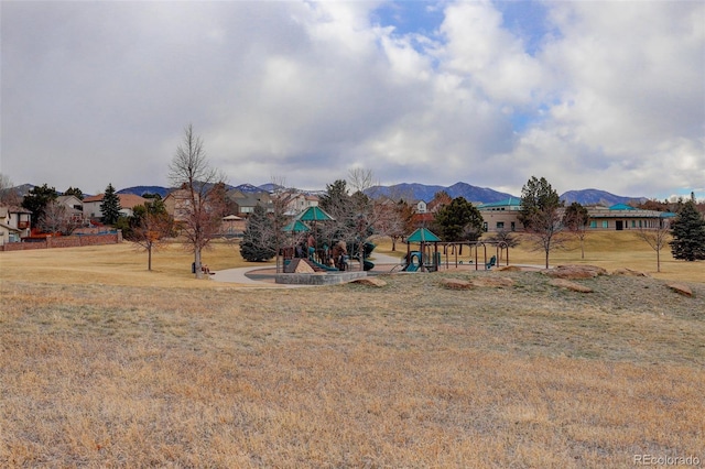 community playground featuring a mountain view and a lawn