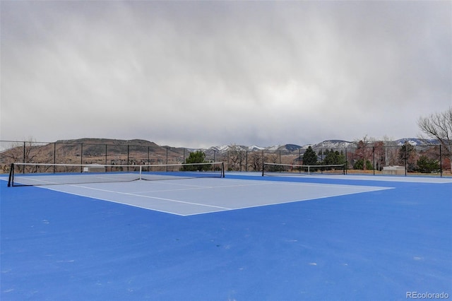 view of sport court with fence and a mountain view