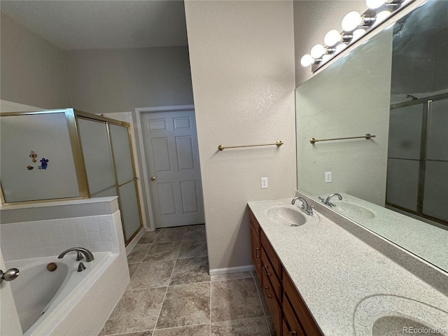 full bathroom with double vanity, a shower stall, a sink, and a garden tub