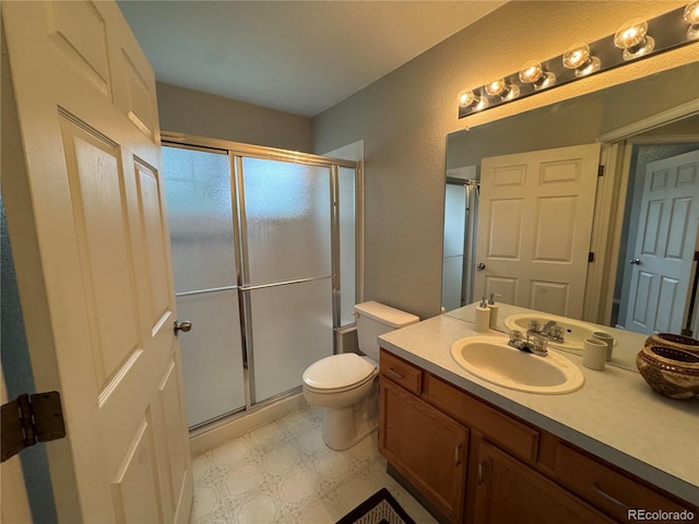 bathroom featuring vanity, tile patterned floors, a stall shower, and toilet