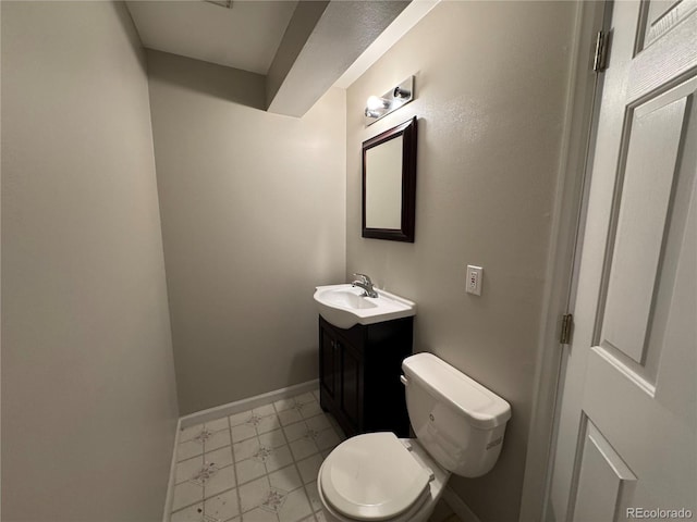 half bathroom featuring vanity, marble finish floor, baseboards, and toilet