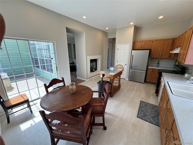dining space with a tiled fireplace and recessed lighting