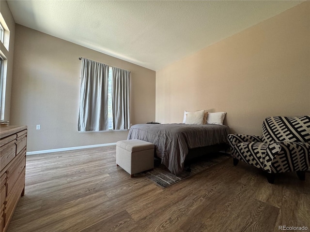 bedroom featuring baseboards and dark wood-style flooring