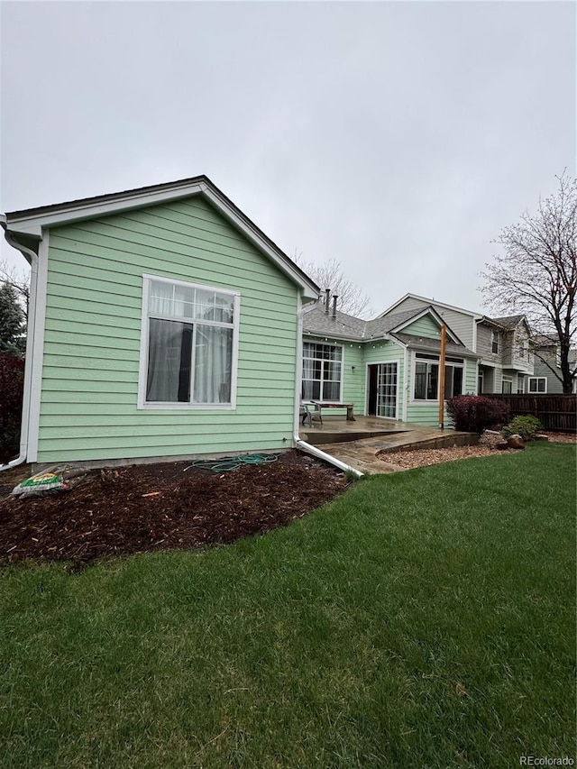 rear view of house with a yard and a patio area