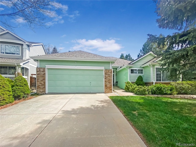 9806 Hooker Ct, Westminster, CO 80031 - view of front facade with brick siding, driveway, a garage, and a front lawn