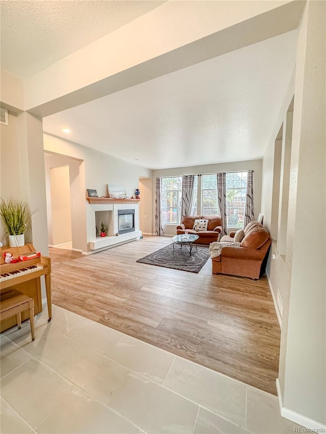 9806 Hooker Ct, Westminster, CO 80031 - living room featuring a tile fireplace, light wood-style floors, and baseboards