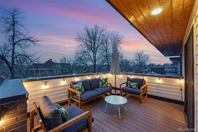 deck at dusk with an outdoor hangout area