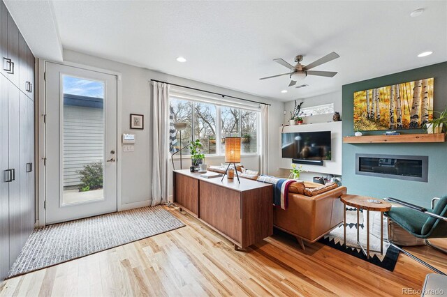living room featuring light wood-style floors, recessed lighting, plenty of natural light, and ceiling fan