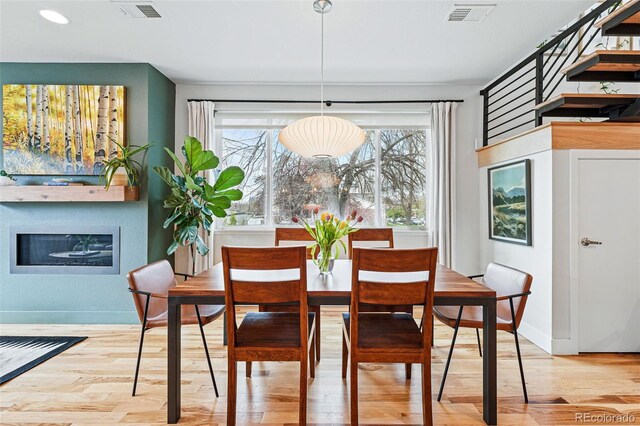 dining room with baseboards, visible vents, and light wood-type flooring