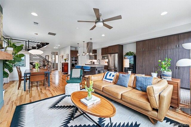 living area with a ceiling fan, recessed lighting, visible vents, and light wood-type flooring