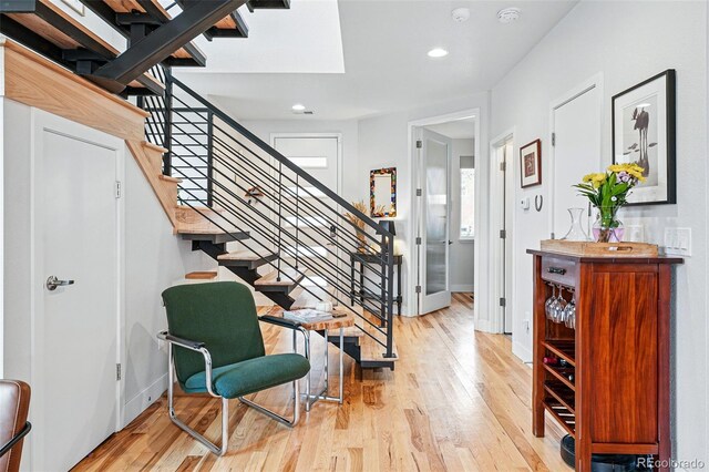 entrance foyer with recessed lighting, baseboards, light wood finished floors, and stairs