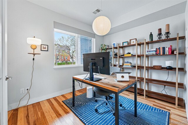 office featuring baseboards, visible vents, and light wood-style floors