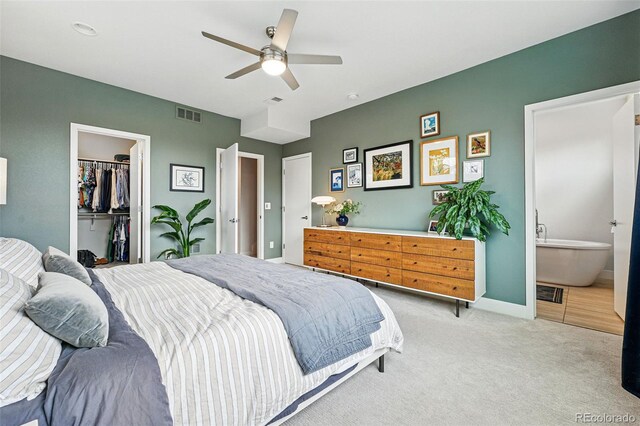 bedroom with visible vents, light carpet, baseboards, a spacious closet, and a ceiling fan
