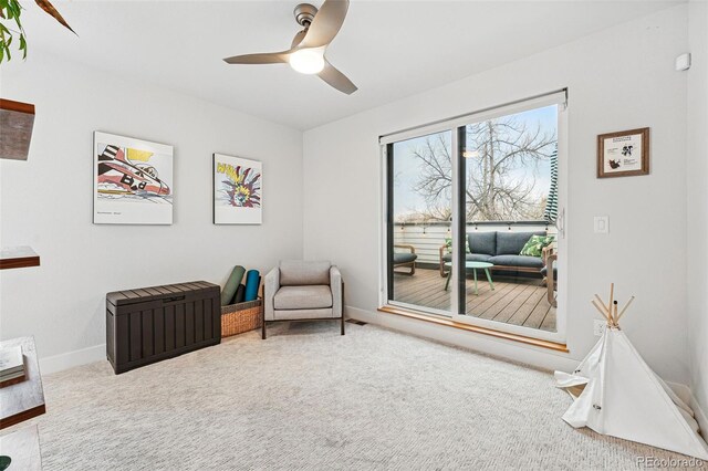 sitting room featuring carpet floors, a ceiling fan, and baseboards