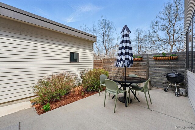 view of patio with outdoor dining space, a fenced backyard, and a grill