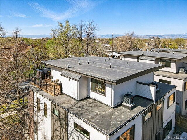 rear view of property with a mountain view and a balcony