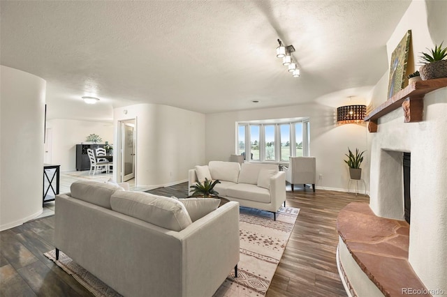 living room with dark hardwood / wood-style floors and a textured ceiling