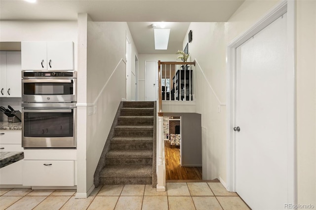 staircase featuring hardwood / wood-style flooring and a skylight