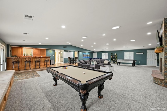 playroom with vaulted ceiling, bar, pool table, a stone fireplace, and light colored carpet