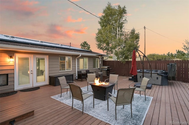 deck at dusk featuring an outdoor living space with a fire pit and area for grilling