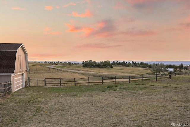 yard at dusk with an outbuilding and a rural view