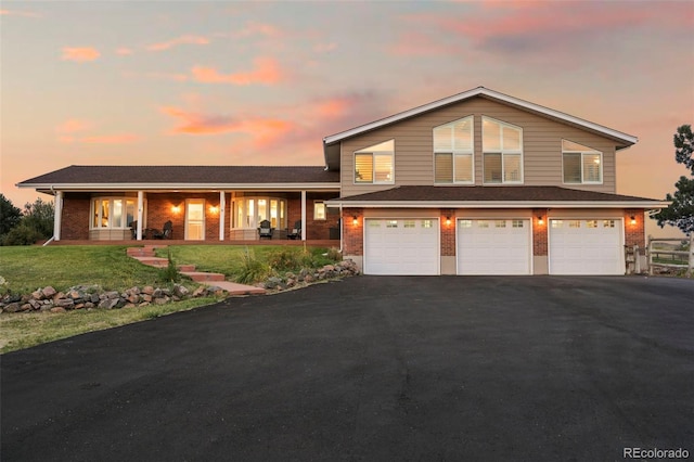 tri-level home with a garage, a porch, and a yard