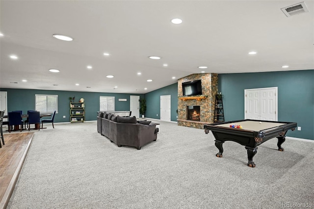 game room featuring vaulted ceiling, light colored carpet, pool table, and a stone fireplace