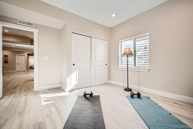 exercise room with light hardwood / wood-style floors