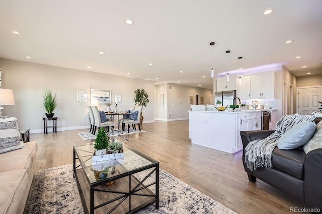 living room featuring light wood-type flooring and sink