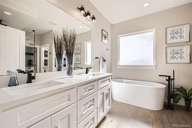 bathroom featuring independent shower and bath, vanity, and wood-type flooring