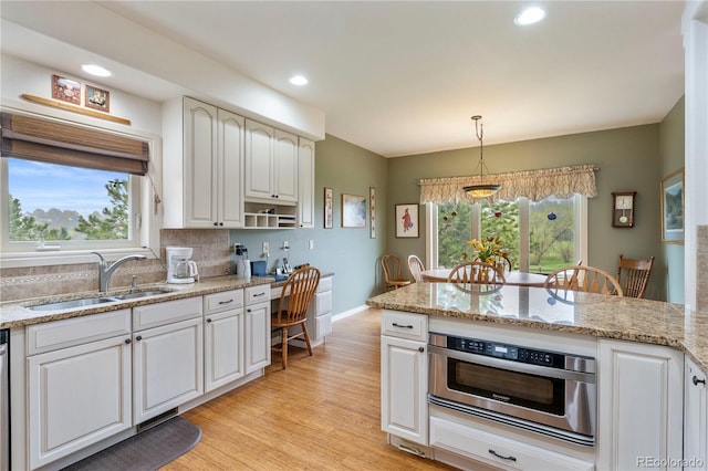 15910 Rhodes Pl, Elbert, CO 80106 - kitchen with a sink, light wood-style flooring, white cabinets, decorative light fixtures, and recessed lighting