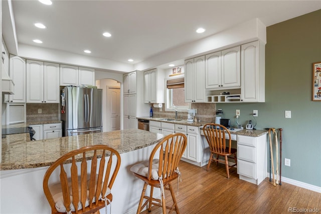 15910 Rhodes Pl, Elbert, CO 80106 - kitchen with appliances with stainless steel finishes, a peninsula, a sink, arched walkways, and recessed lighting