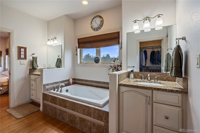 15910 Rhodes Pl, Elbert, CO 80106 - full bath featuring wood finished floors, a garden tub, vanity, connected bathroom, and a spacious closet