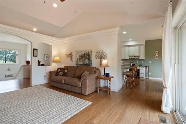15910 Rhodes Pl, Elbert, CO 80106 - living area featuring lofted ceiling, wood finished floors, arched walkways, ceiling fan, and recessed lighting