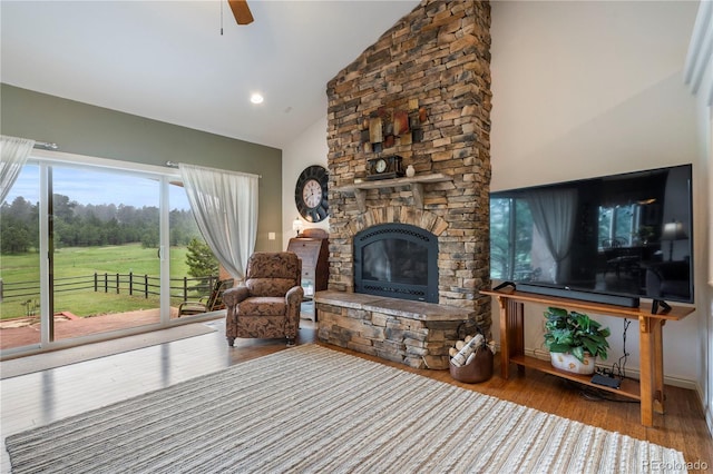 15910 Rhodes Pl, Elbert, CO 80106 - living area featuring a stone fireplace, high vaulted ceiling, wood finished floors, and a ceiling fan