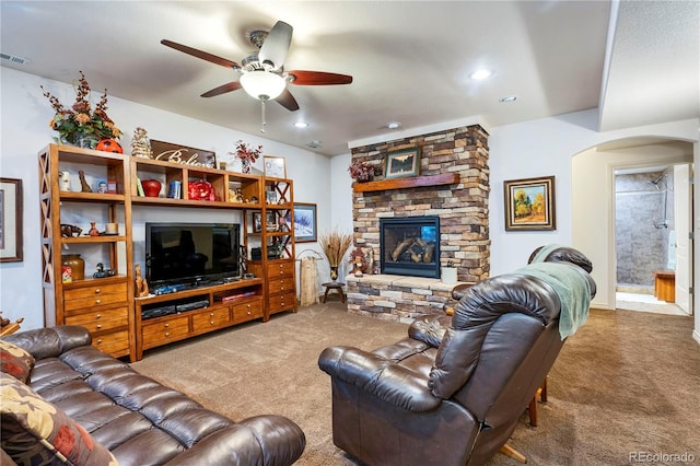 15910 Rhodes Pl, Elbert, CO 80106 - carpeted living area featuring arched walkways, ceiling fan, and a stone fireplace