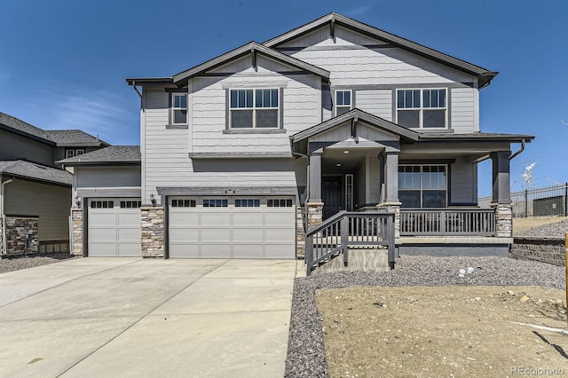 2968 S Poppy St, Morrison, CO 80465 - craftsman-style house with concrete driveway, stone siding, an attached garage, and covered porch