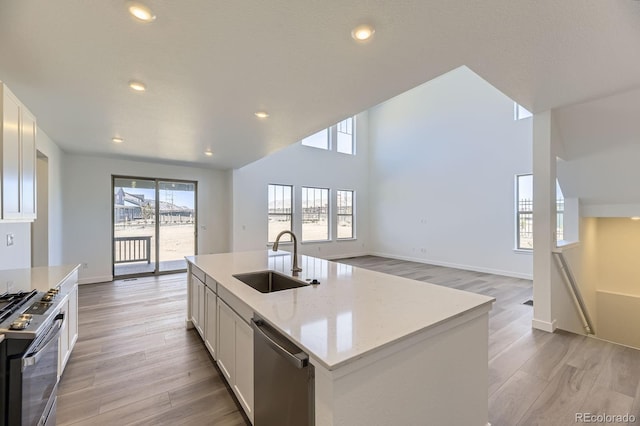 2968 S Poppy St, Morrison, CO 80465 - kitchen with light wood-style flooring, white cabinetry, light stone countertops, appliances with stainless steel finishes, and a sink