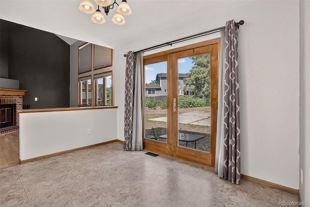 10181 Detroit Ct, Thornton, CO 80229 - spare room with a chandelier, french doors, a brick fireplace, and lofted ceiling