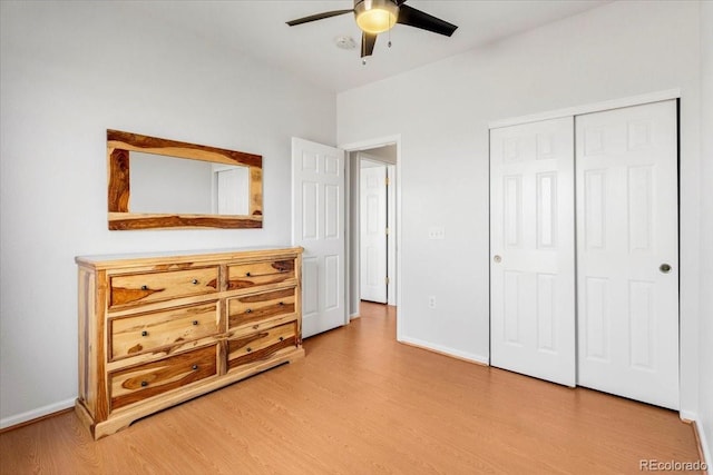 bedroom with a closet, light wood-type flooring, a ceiling fan, and baseboards