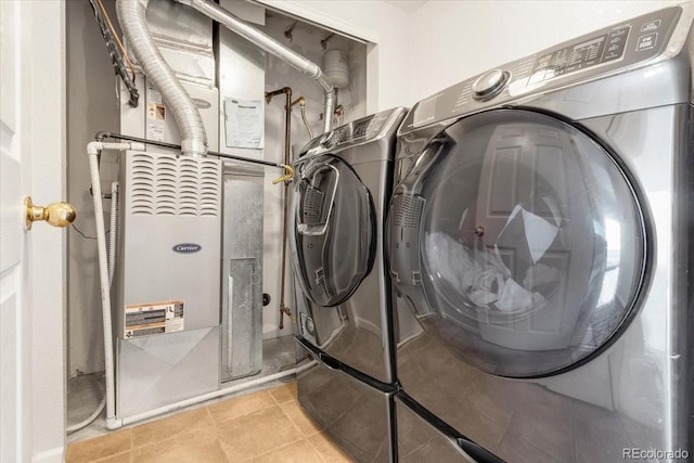 clothes washing area with tile patterned flooring, laundry area, and washer and clothes dryer