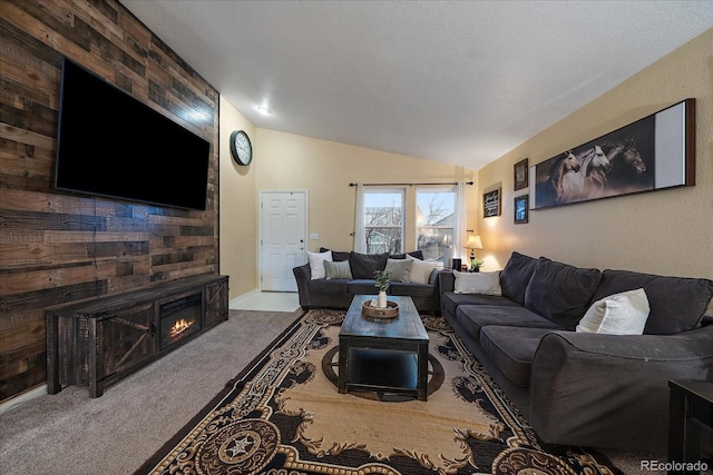 living room featuring a large fireplace, vaulted ceiling, carpet flooring, and wood walls