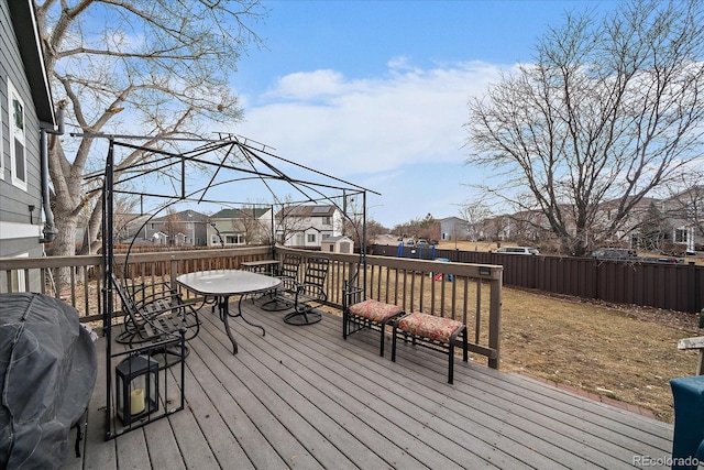 wooden deck with a fenced backyard, a residential view, and grilling area