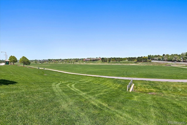 view of community featuring a lawn and a rural view