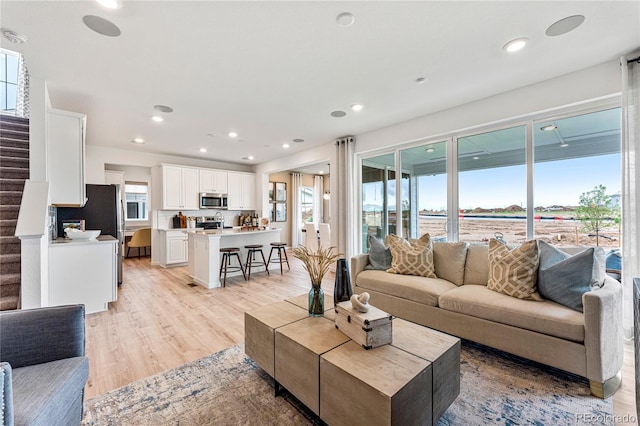 3331 N Buchanan Way, Aurora, CO 80019 - living room featuring stairs, recessed lighting, and light wood-style floors
