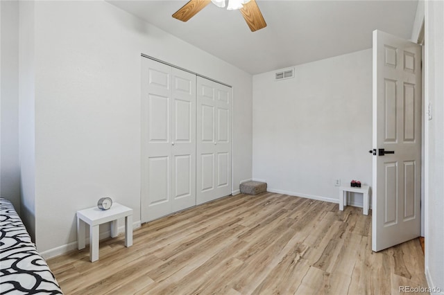 bedroom with ceiling fan, light hardwood / wood-style floors, and a closet