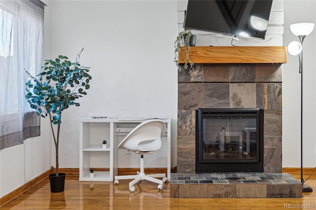 details featuring hardwood / wood-style flooring and a tiled fireplace