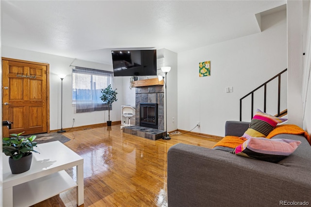 living room with hardwood / wood-style floors and a tile fireplace